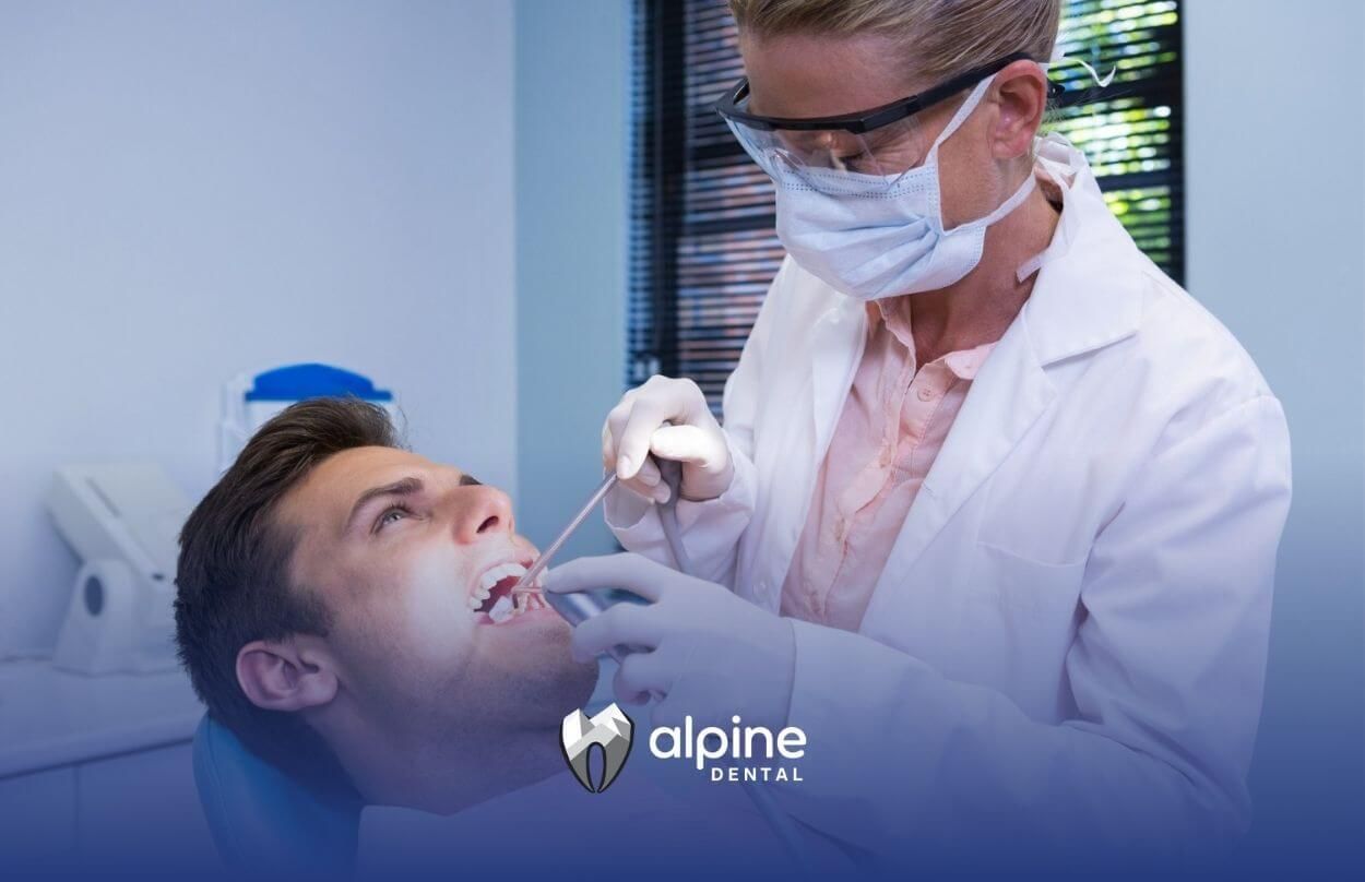 Dentist examining a male patient's teeth.

