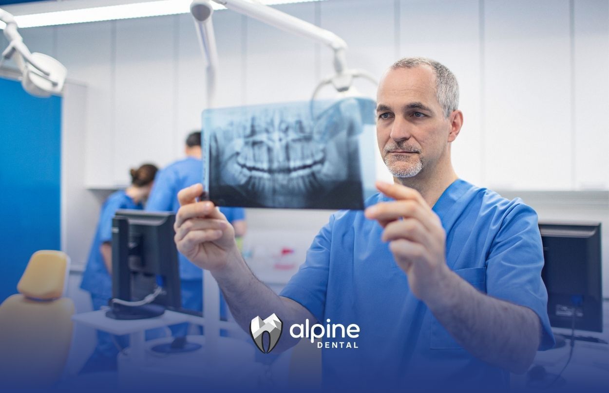 A dentist is holding an X-ray of a patient's teeth in a dental office.