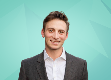 A man in a suit and white shirt is smiling for the camera.