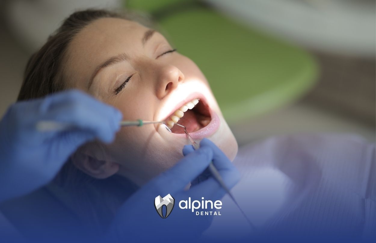 A woman is getting her teeth examined by a dentist.
