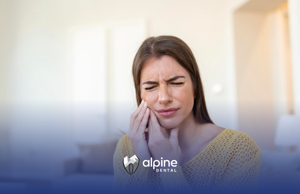 A woman is holding her face in pain because of a toothache.