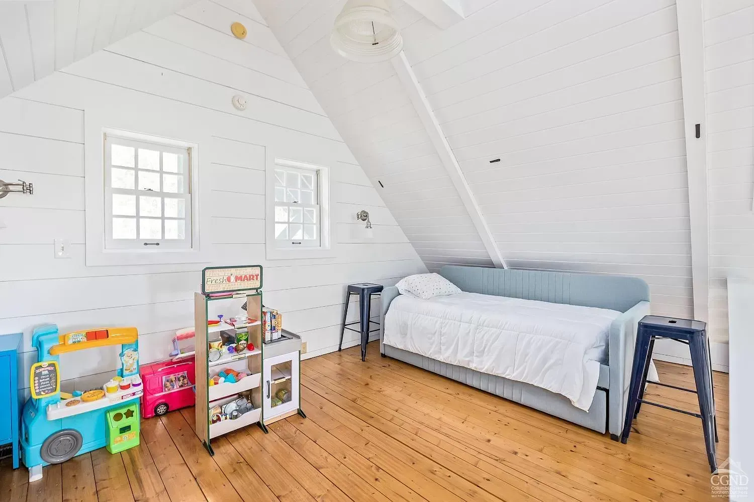 A bedroom with a bed , couch , and toys on the floor.