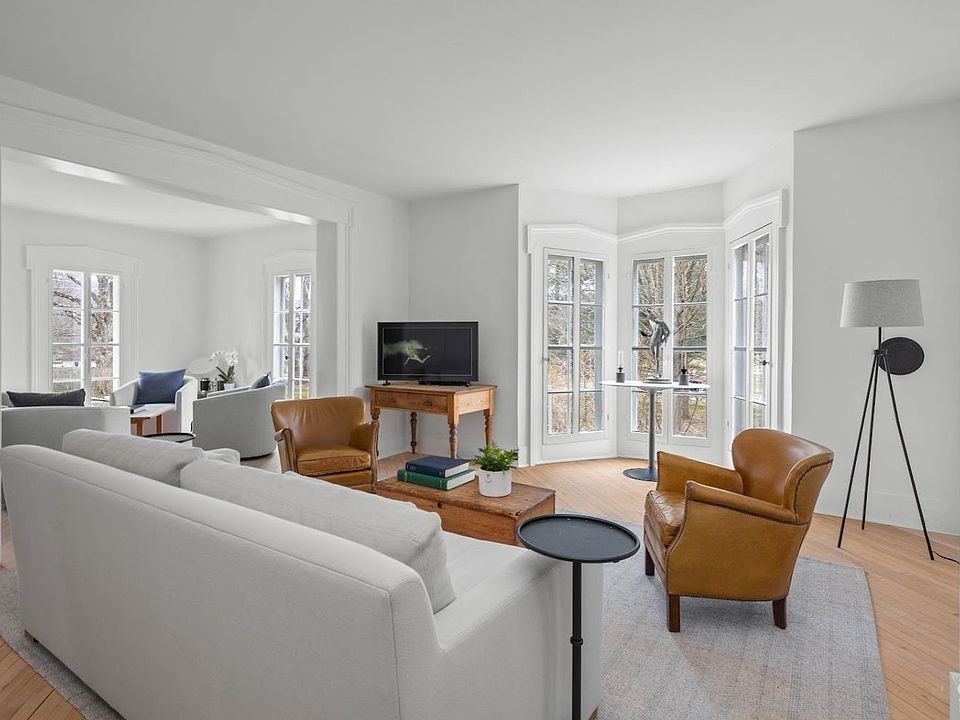 A living room with a couch , chairs , and a television.