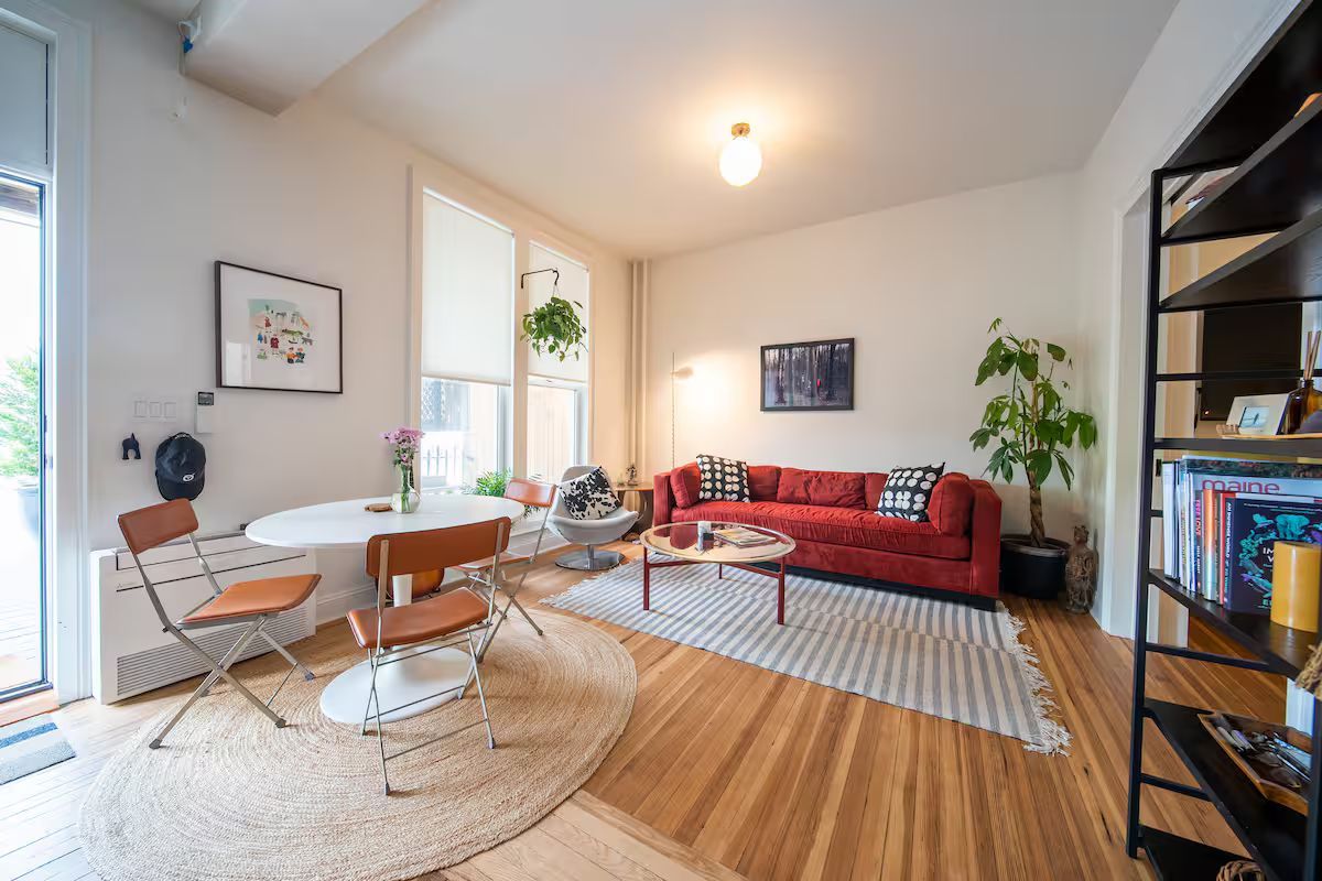 A living room with a red couch , table and chairs.