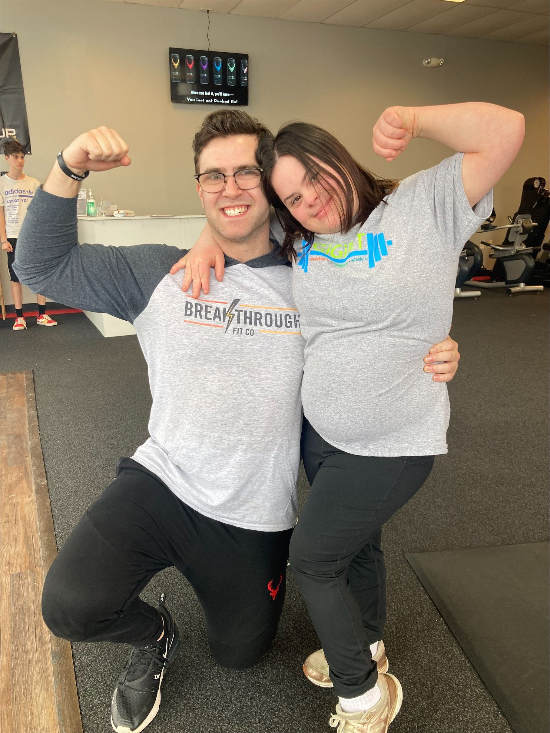 A man and a woman are posing for a picture in a gym.