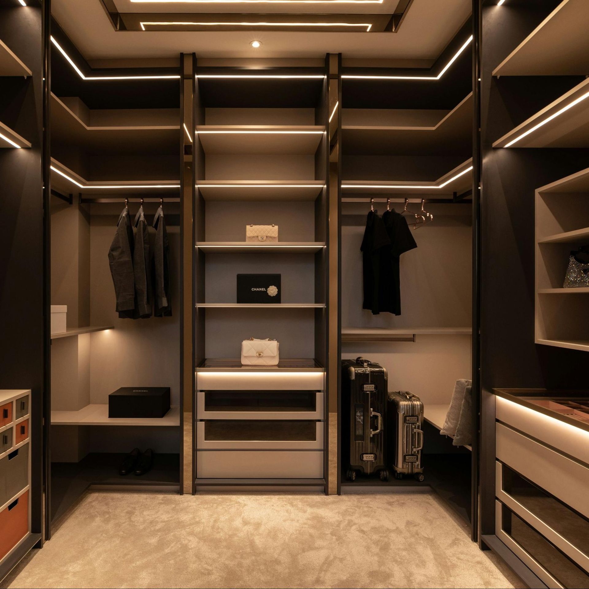 A walk in closet with lots of shelves and drawers