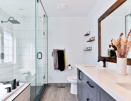 A bathroom with a sink , toilet , shower and mirror.