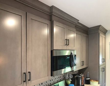 A kitchen with stainless steel appliances and gray cabinets