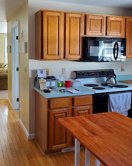 A kitchen with wooden cabinets a stove and a microwave