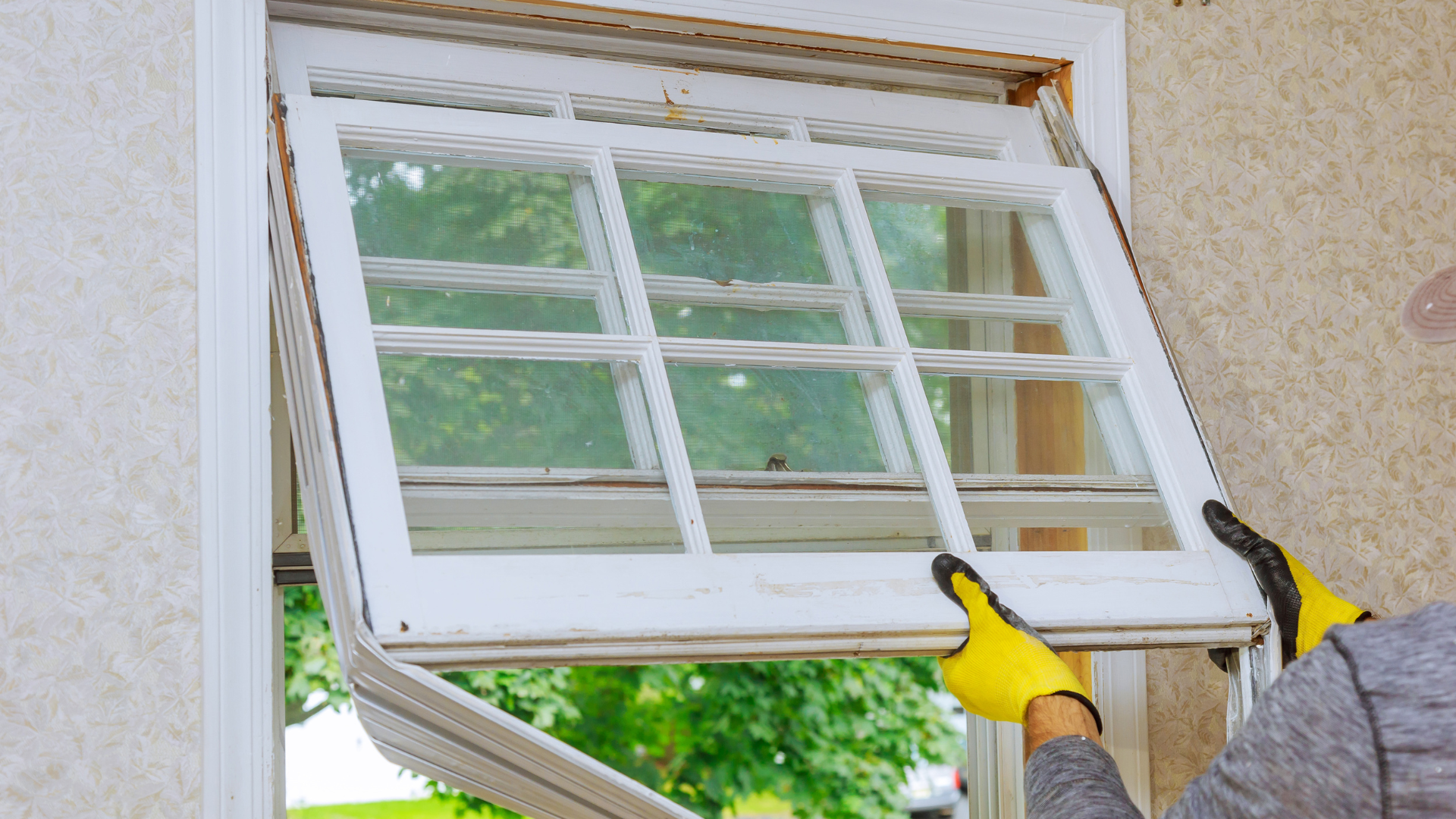 A man is installing a window in a house.