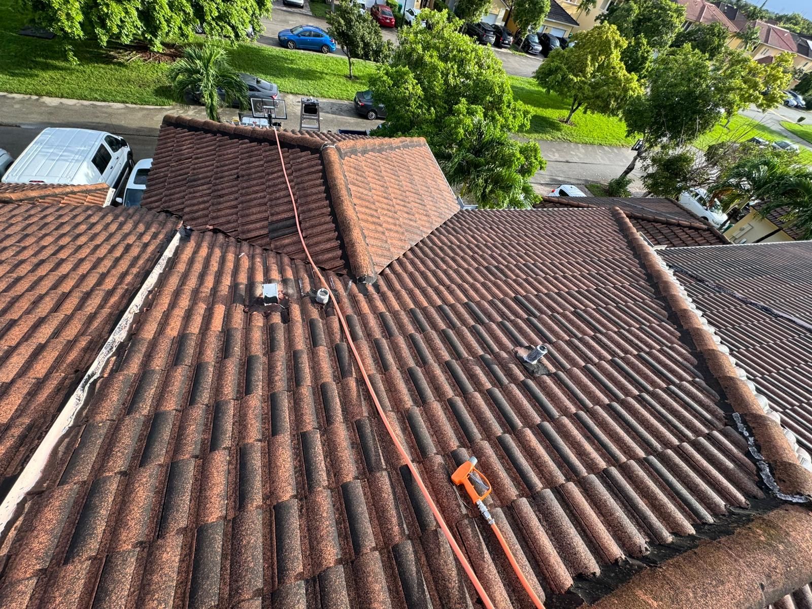 Brown tile roof with orange safety equipment; view from above.