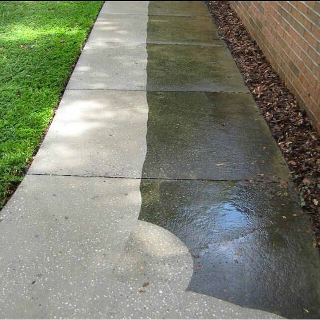 Concrete sidewalk, half cleaned by power washing, showing before and after.