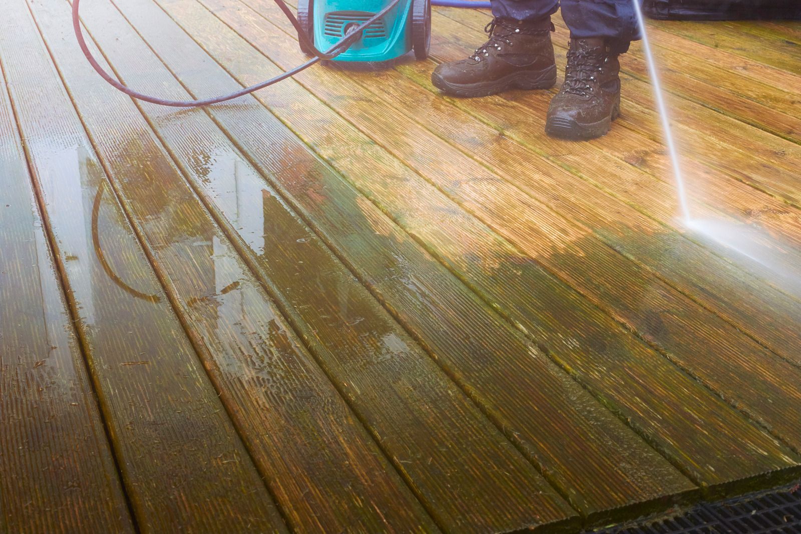 A surface cleaner is being used to clean a concrete surface, removing dirt and grime.