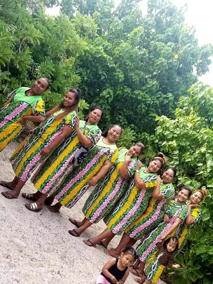 Group of women in colorful dresses standing outdoors.