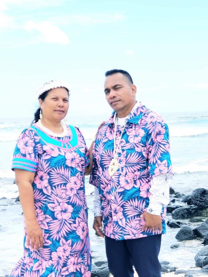 Couple in floral matching outfits by the ocean.