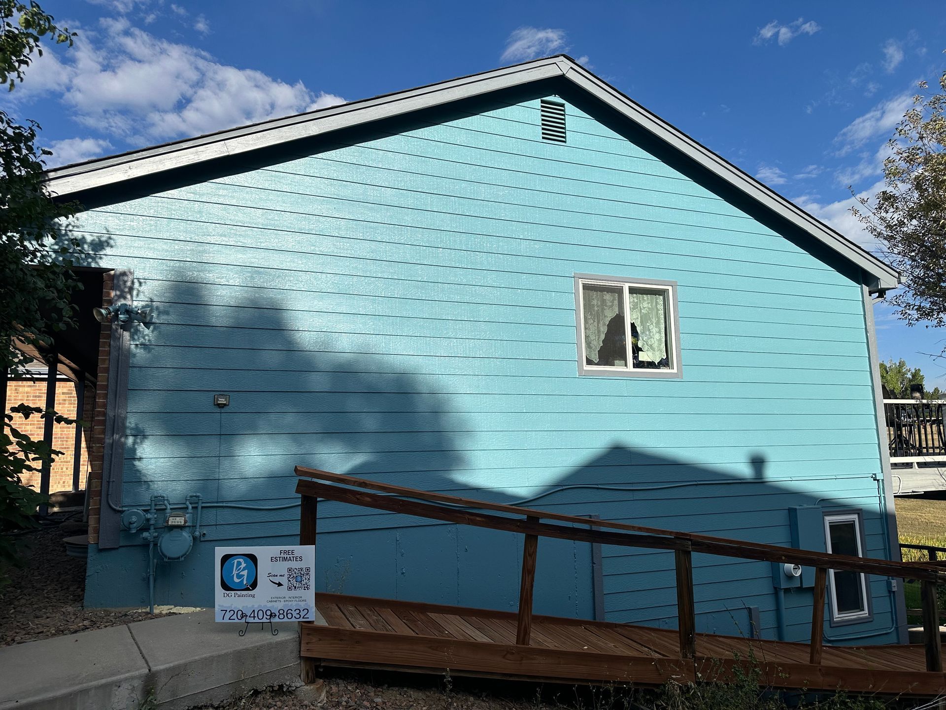 Blue house with a wheelchair ramp on a sunny day.