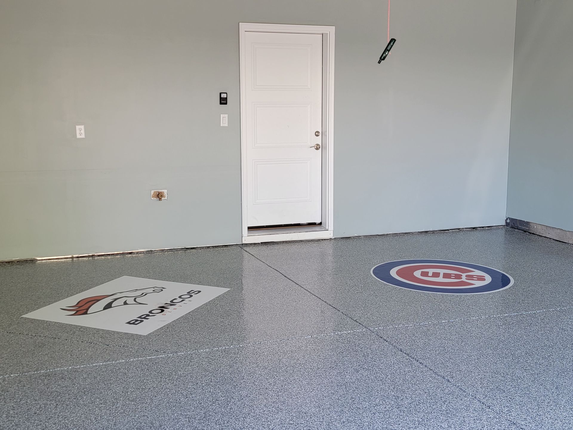 A garage with a door and a logo on the floor.