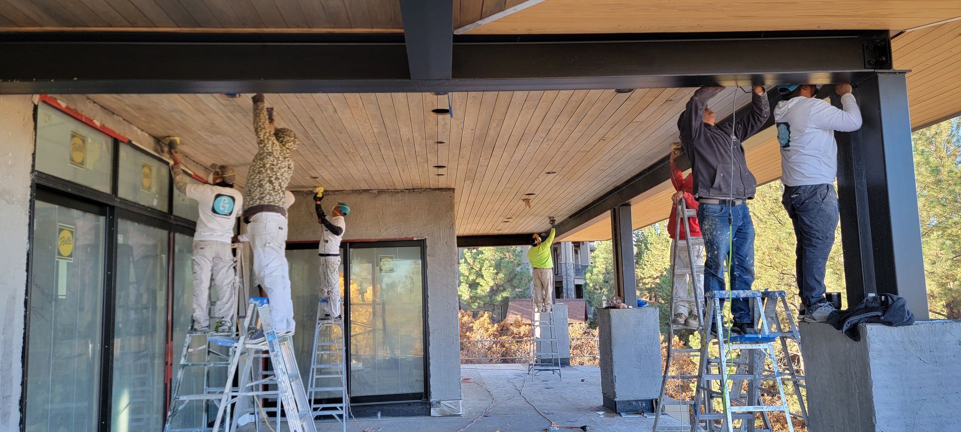 A group of men are working on the ceiling of a building.
