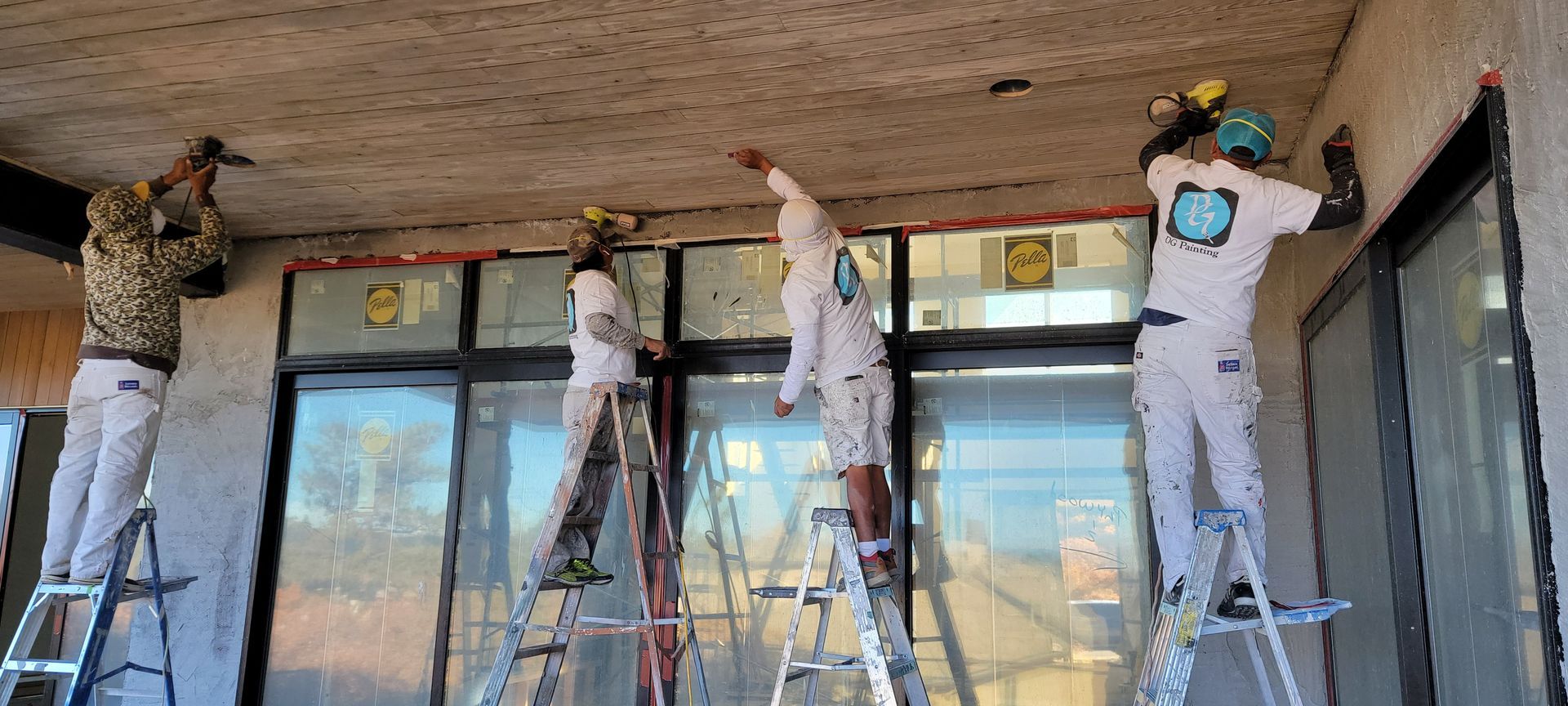A group of people are painting the ceiling of a building.
