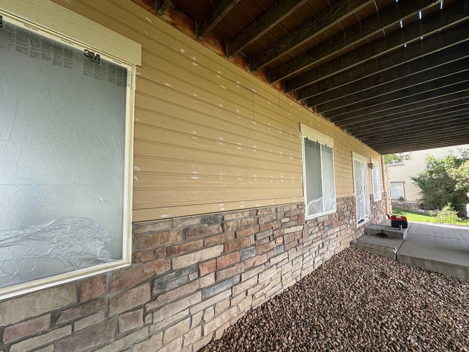 A house with a covered porch and a brick wall.