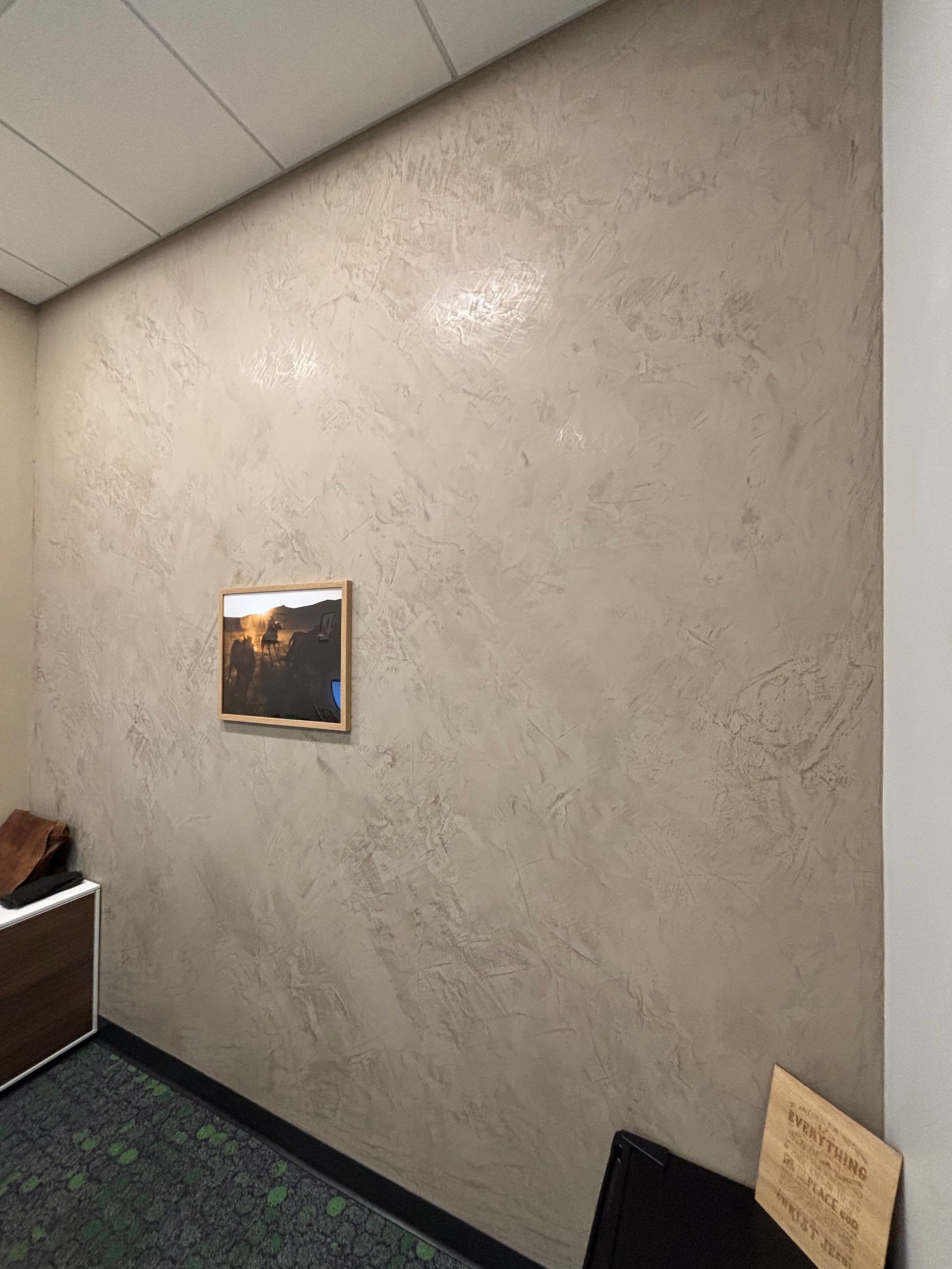 A picture is hanging on a wall in a room.