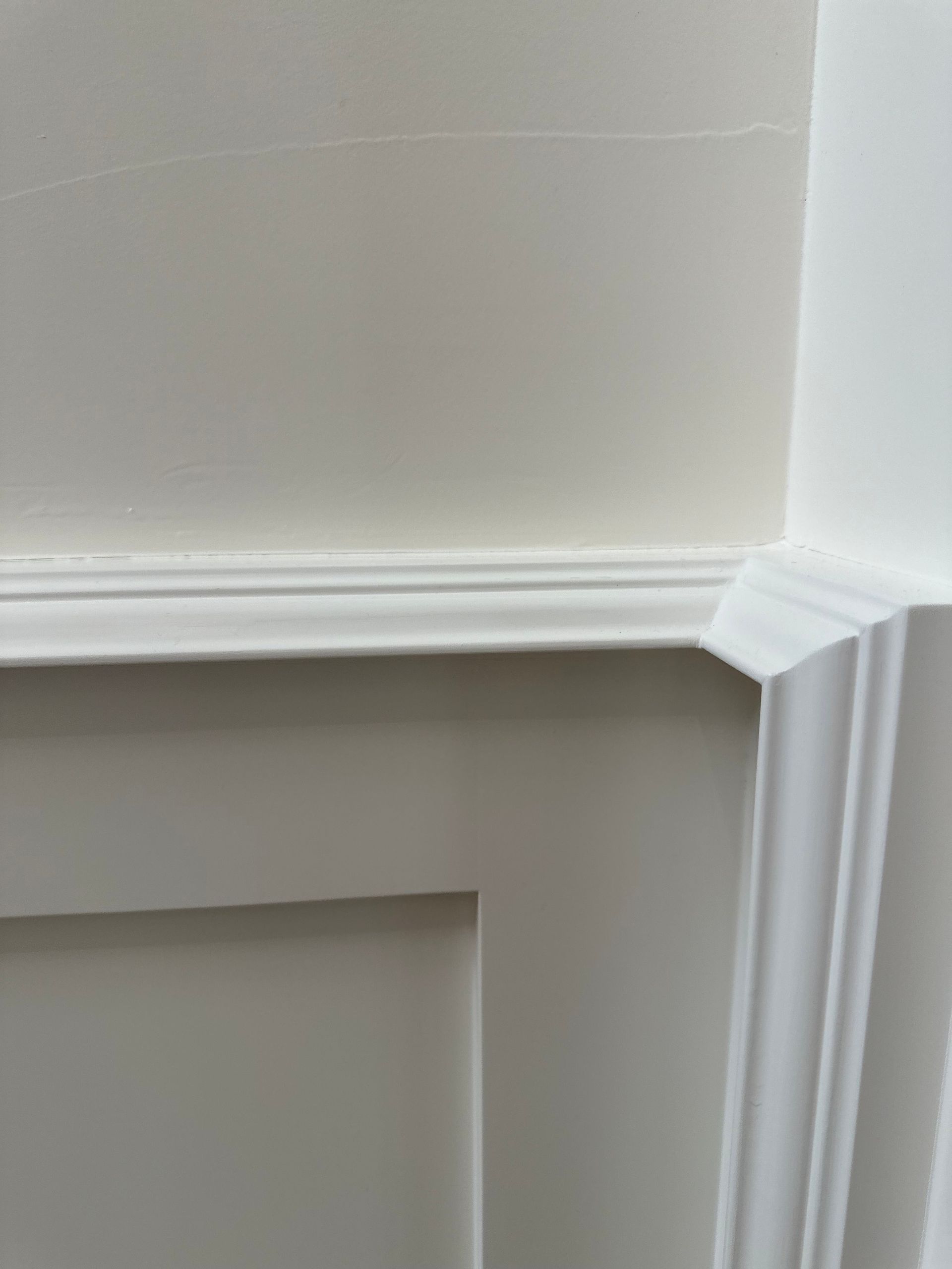 A close up of a white wall with a white trim.