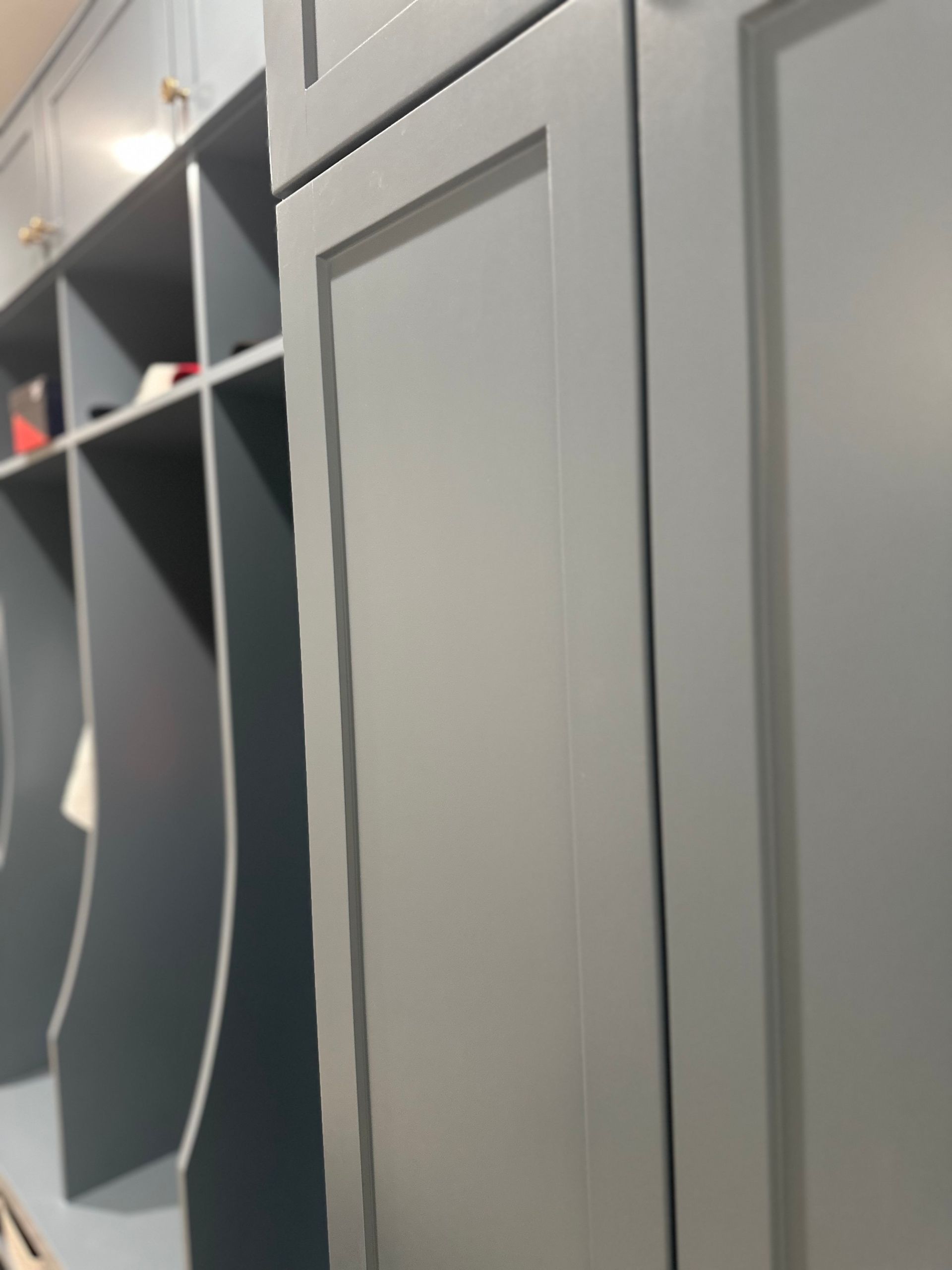 A close up of a closet with gray cabinets and shelves