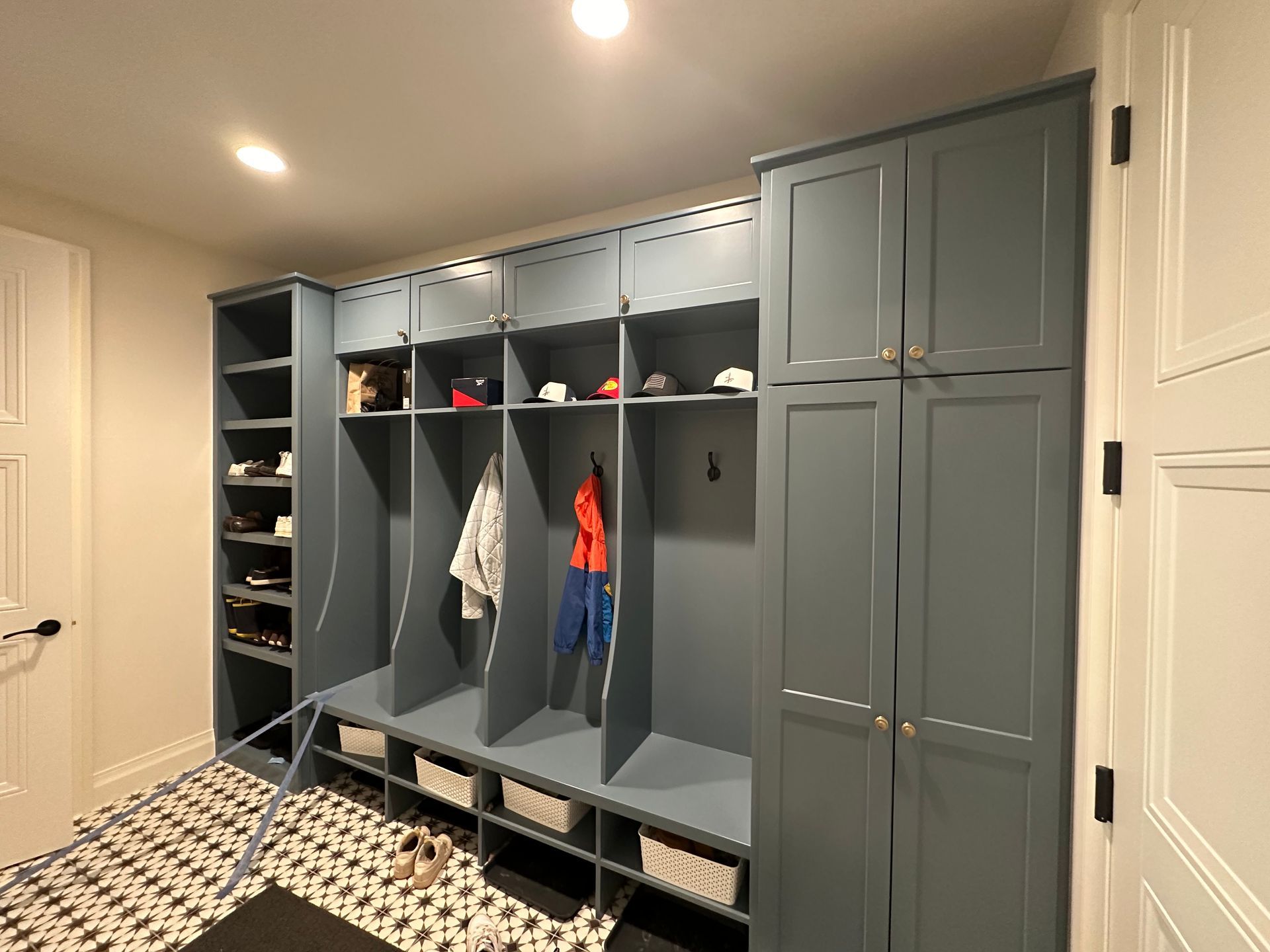 A mud room with a lot of cabinets and shelves.