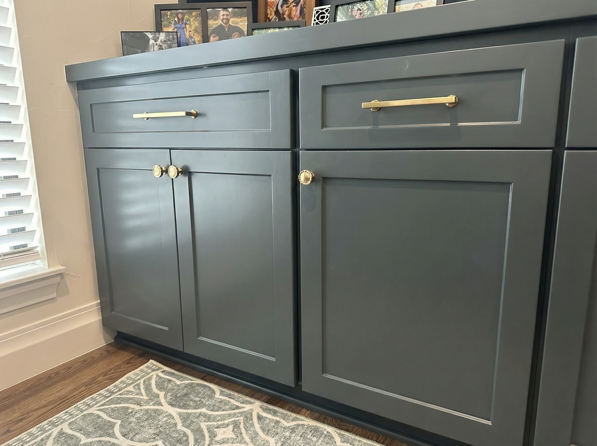 A close up of a cabinet with pictures on top of it in a living room.