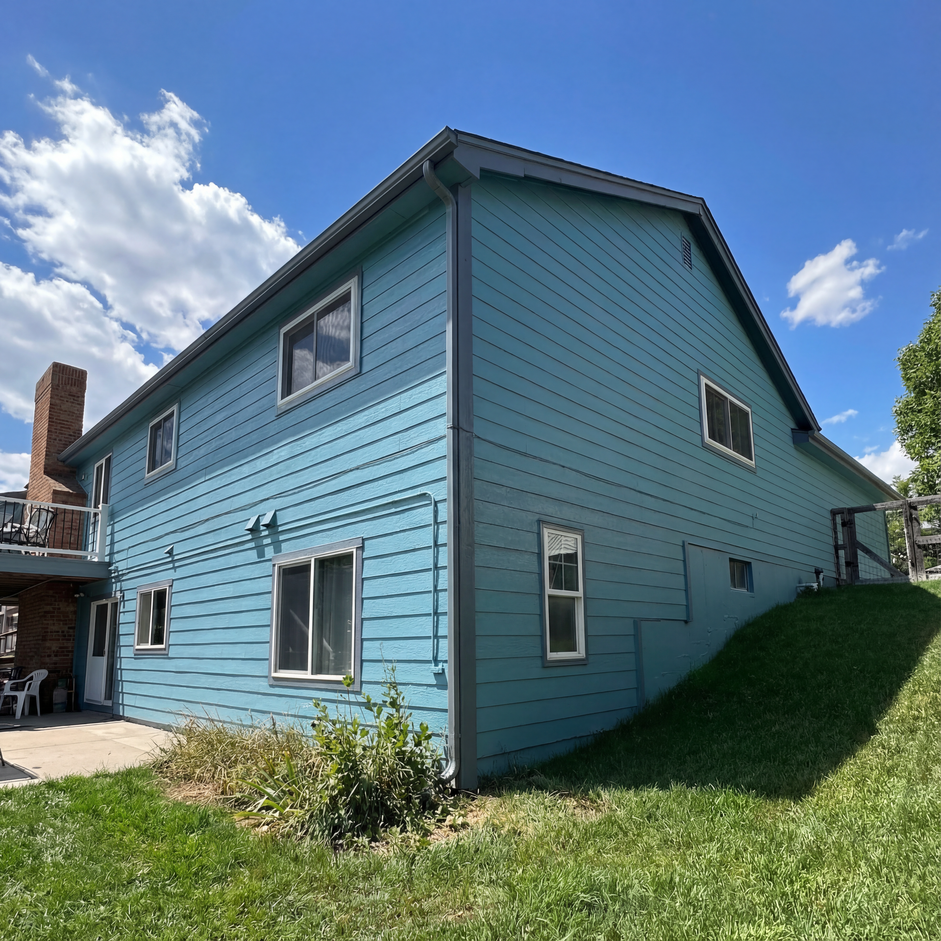 A blue house with a sign in front of it.