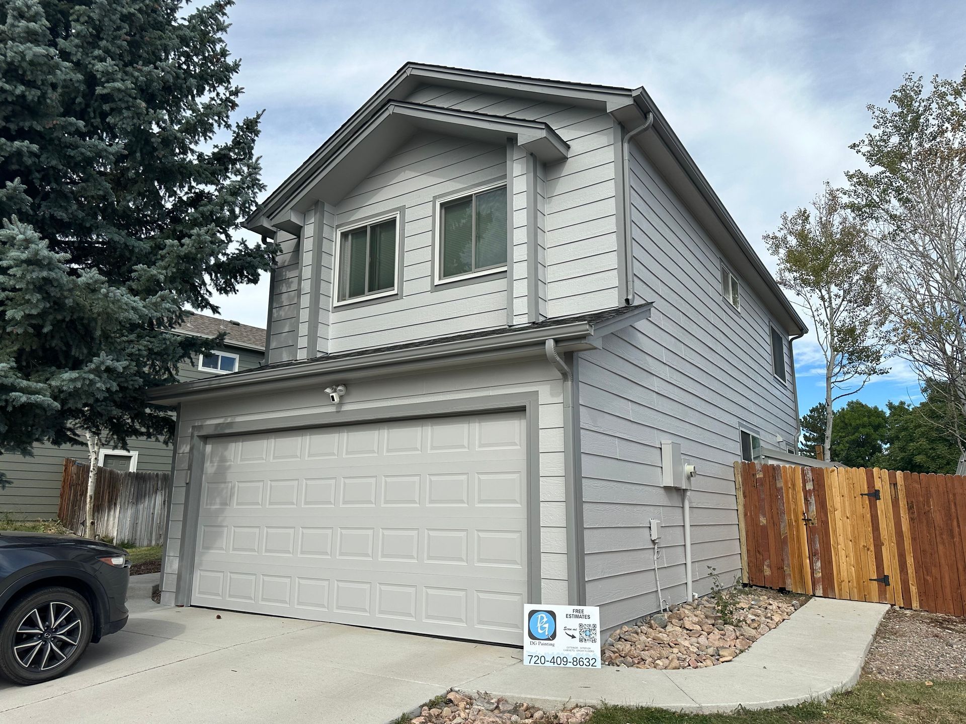 A white house with a car parked in front of it