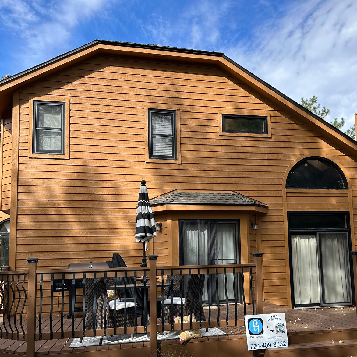 The back of a house with a large deck and stairs.