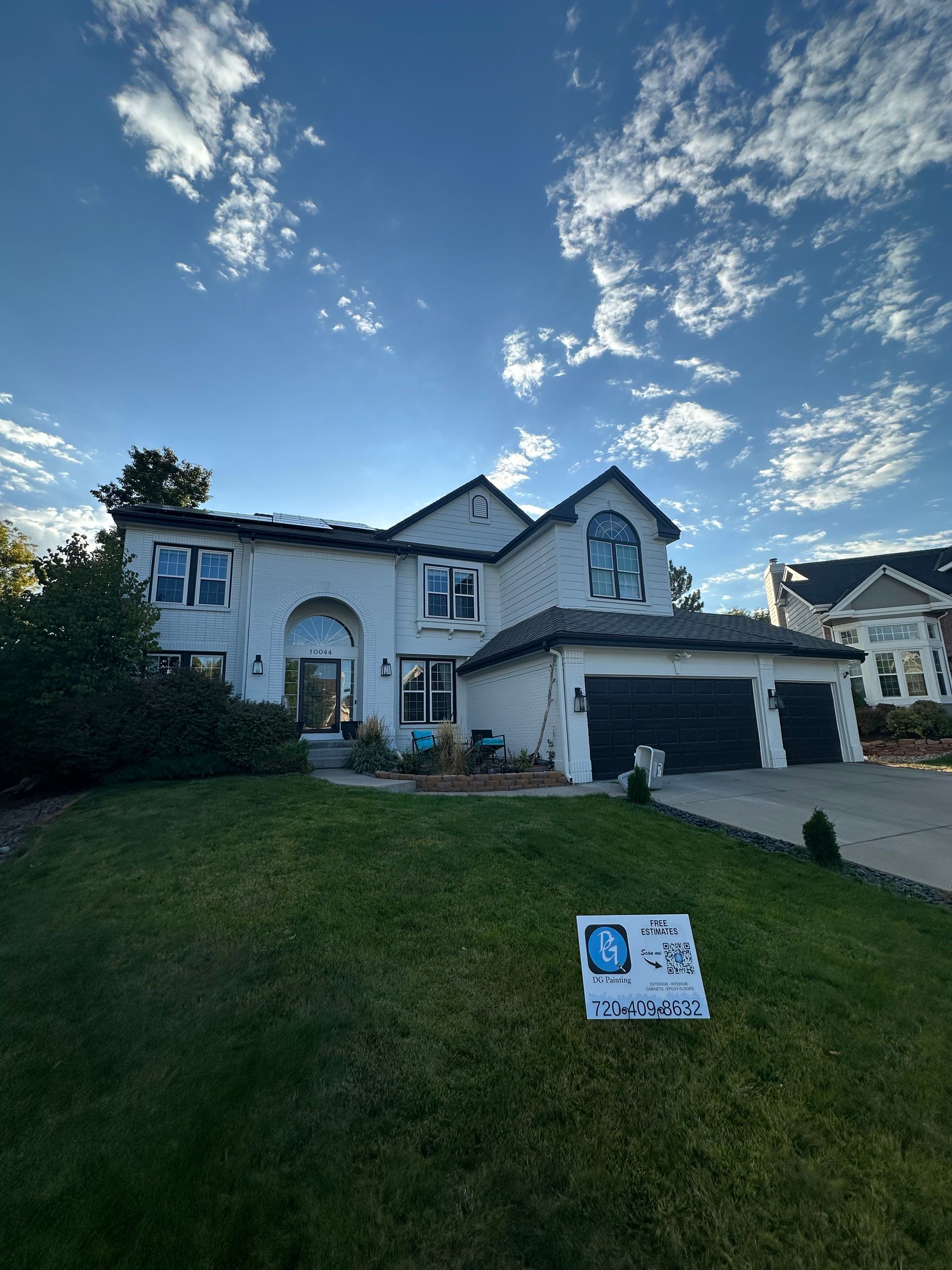 A large white house with a sign in front of it.