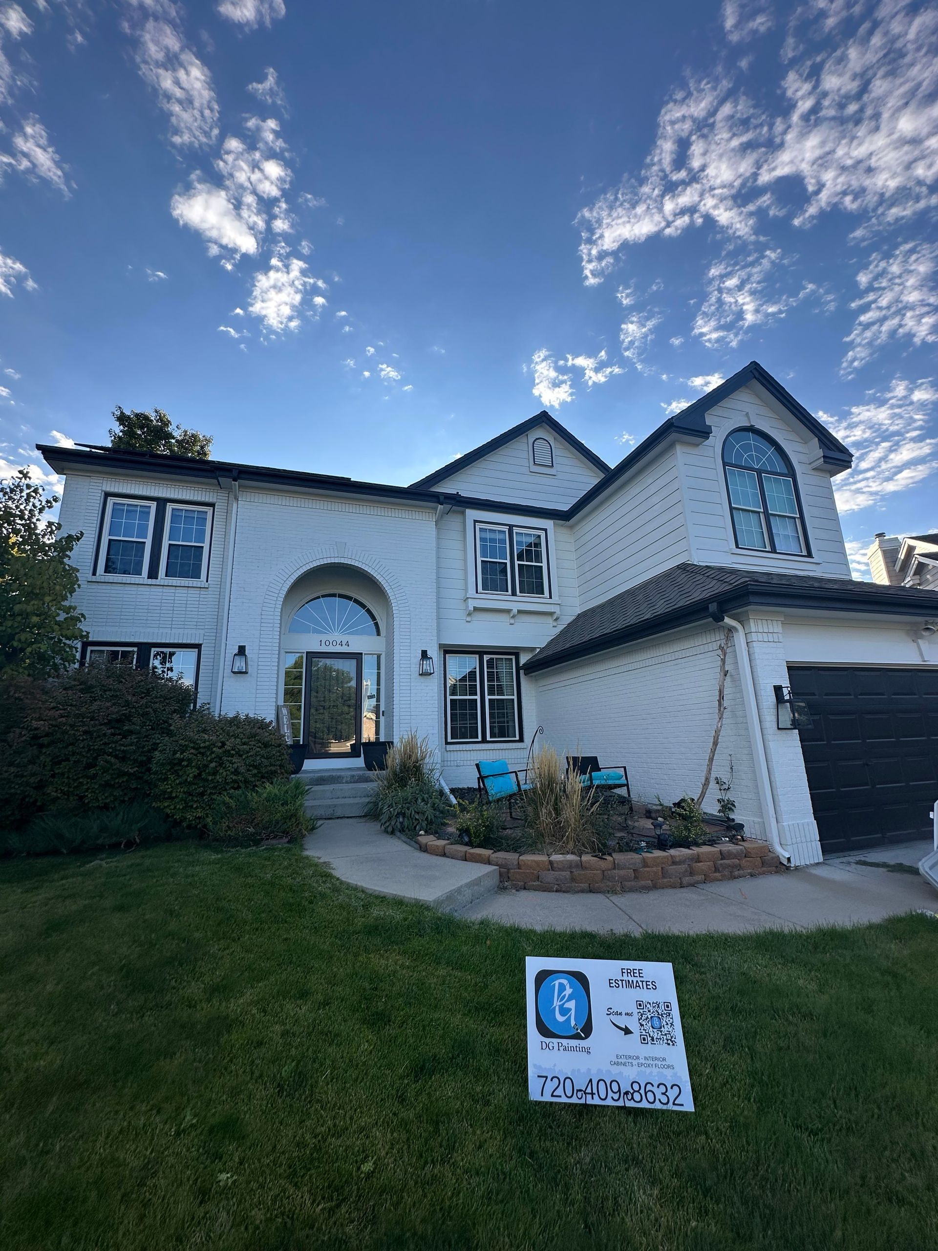 A large white house with a sign in front of it.