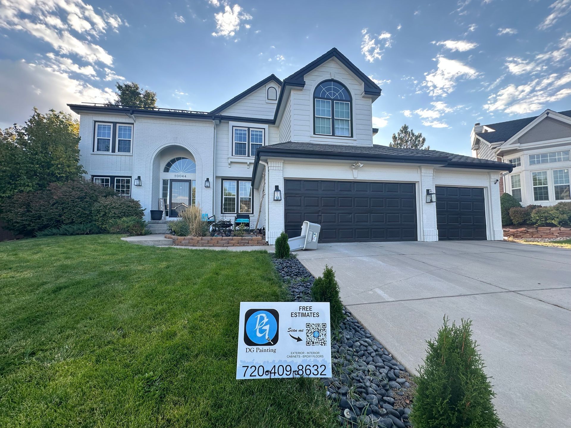 A large white house with a sign in front of it.