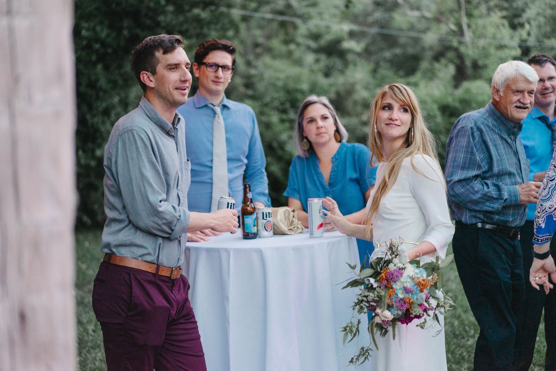Guests gathered with drinks around an outdoor cocktail table