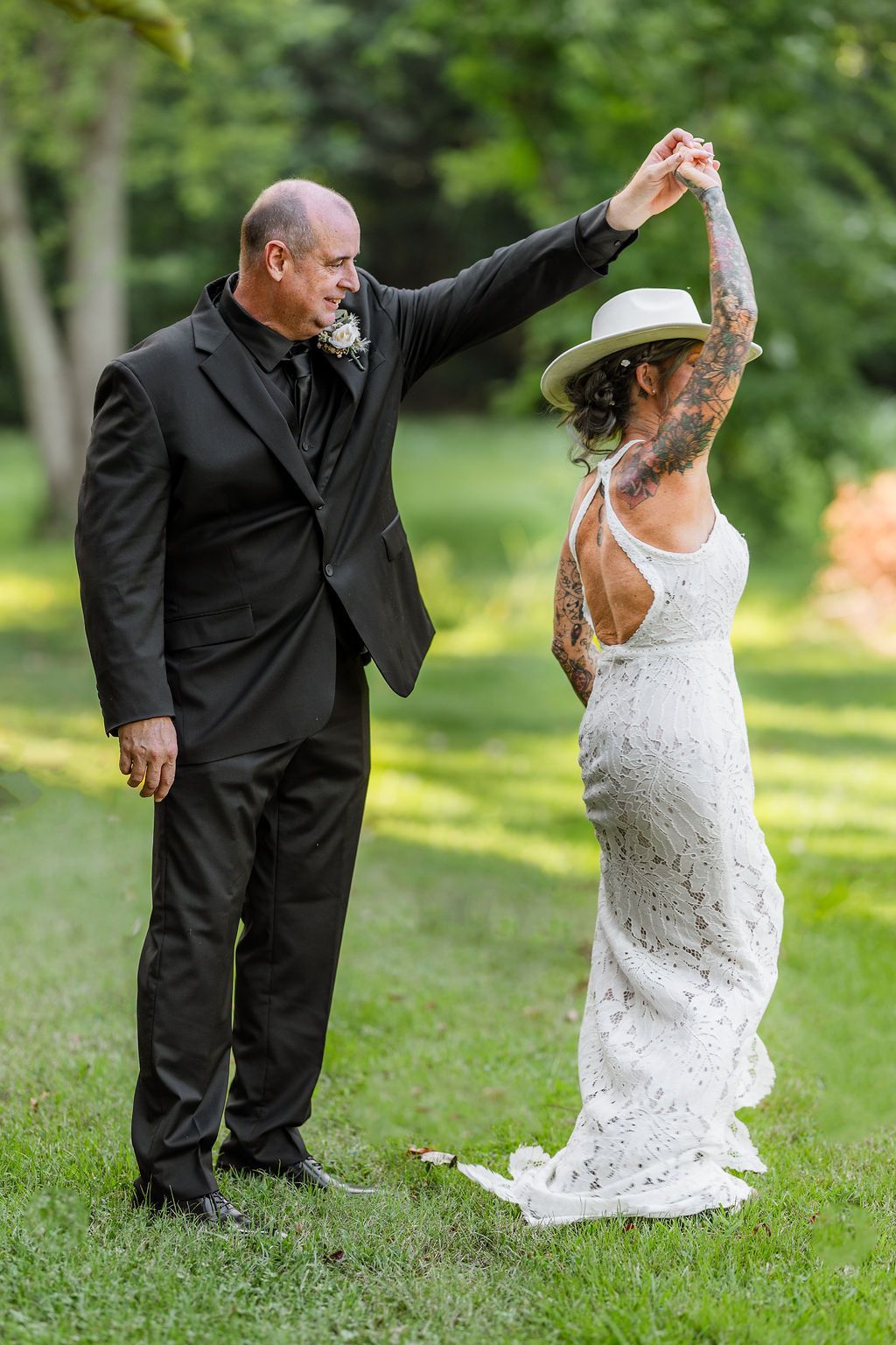 Groom spinning bride outdoors