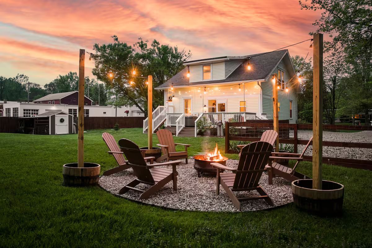 Pewee Valley home at dusk with fire pit and string lights