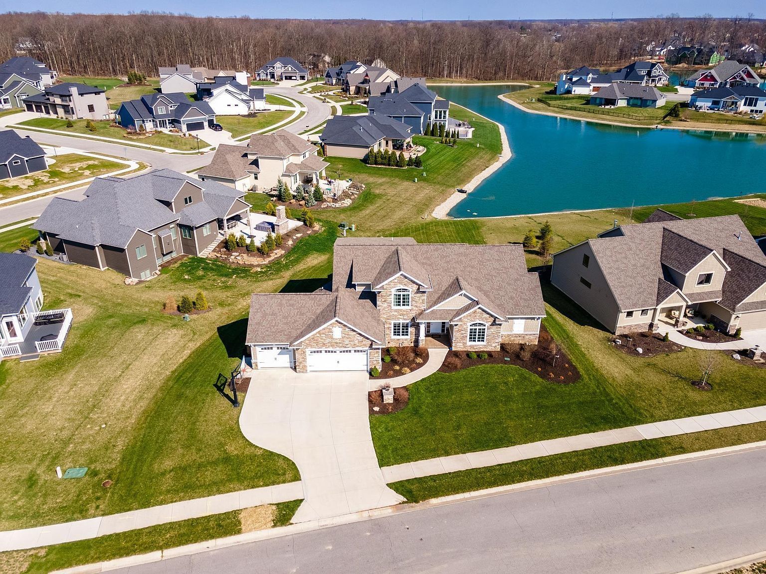 Black metal roof of a house, set against a light blue sky.