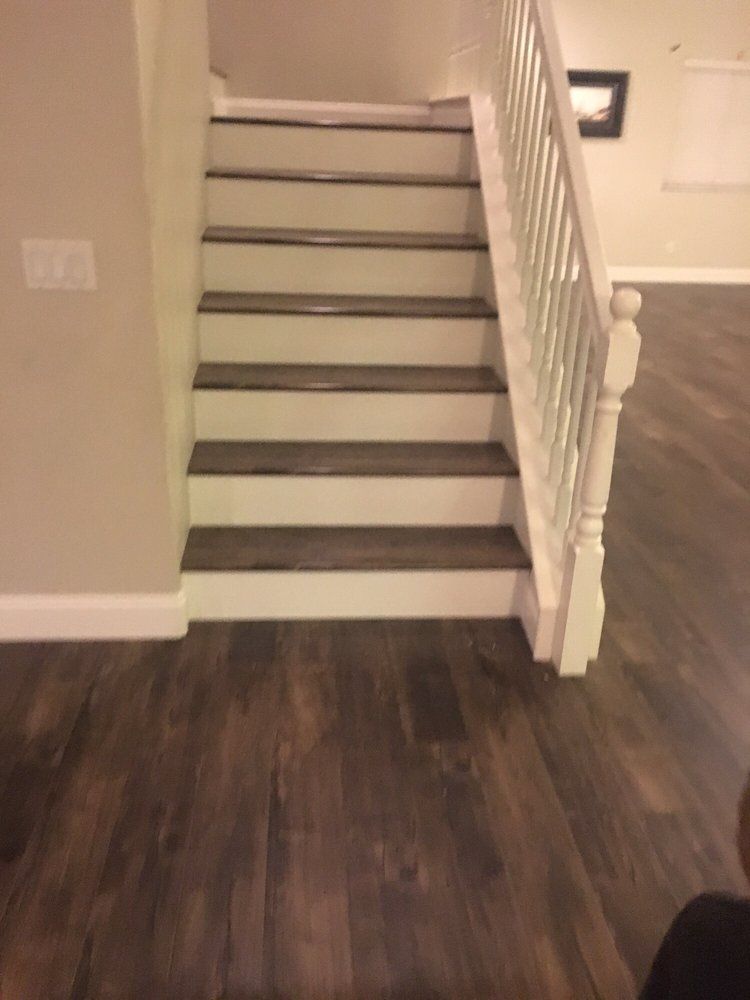 A staircase with dark wood treads and white risers, featuring a white balustrade, set against light beige walls.