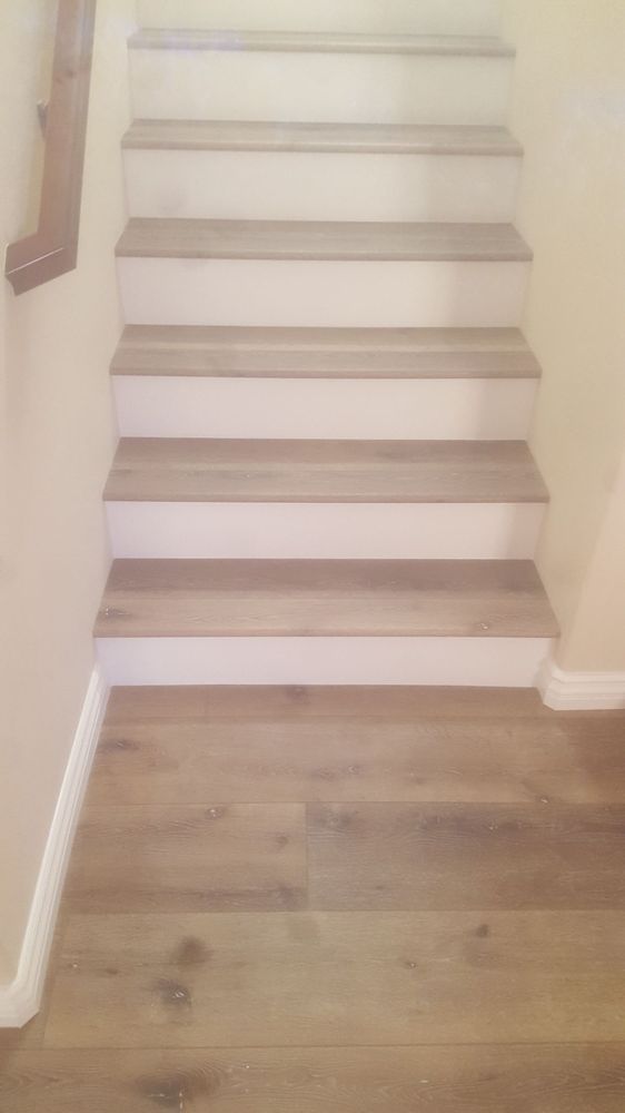 A set of indoor stairs with light wood treads and white risers, viewed from the bottom looking up.