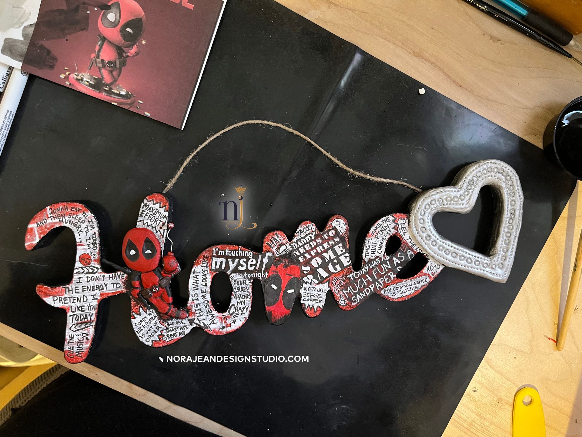 A diy sign that says home with deadpool on it