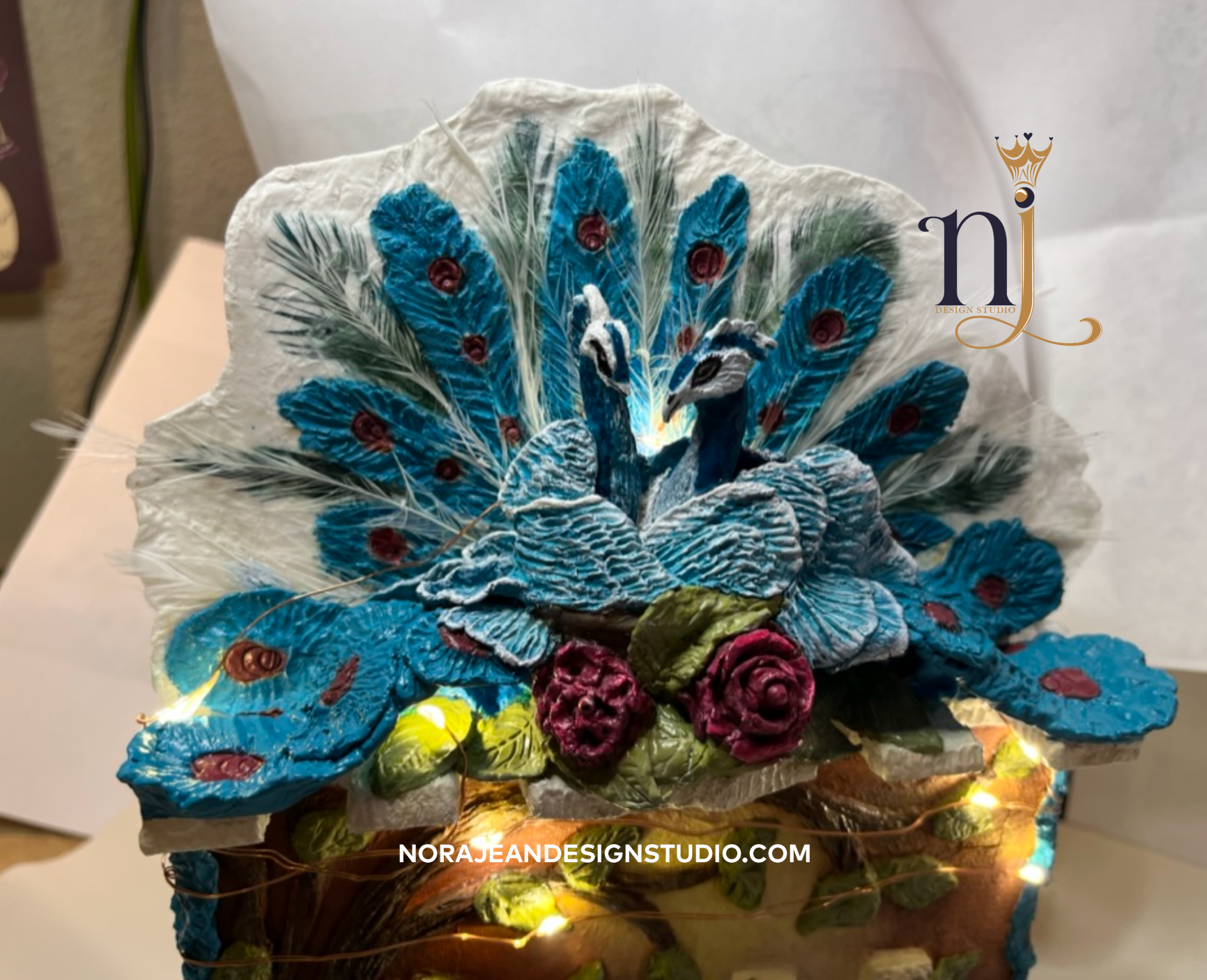 A box with a diy sculpted peacock on top of it