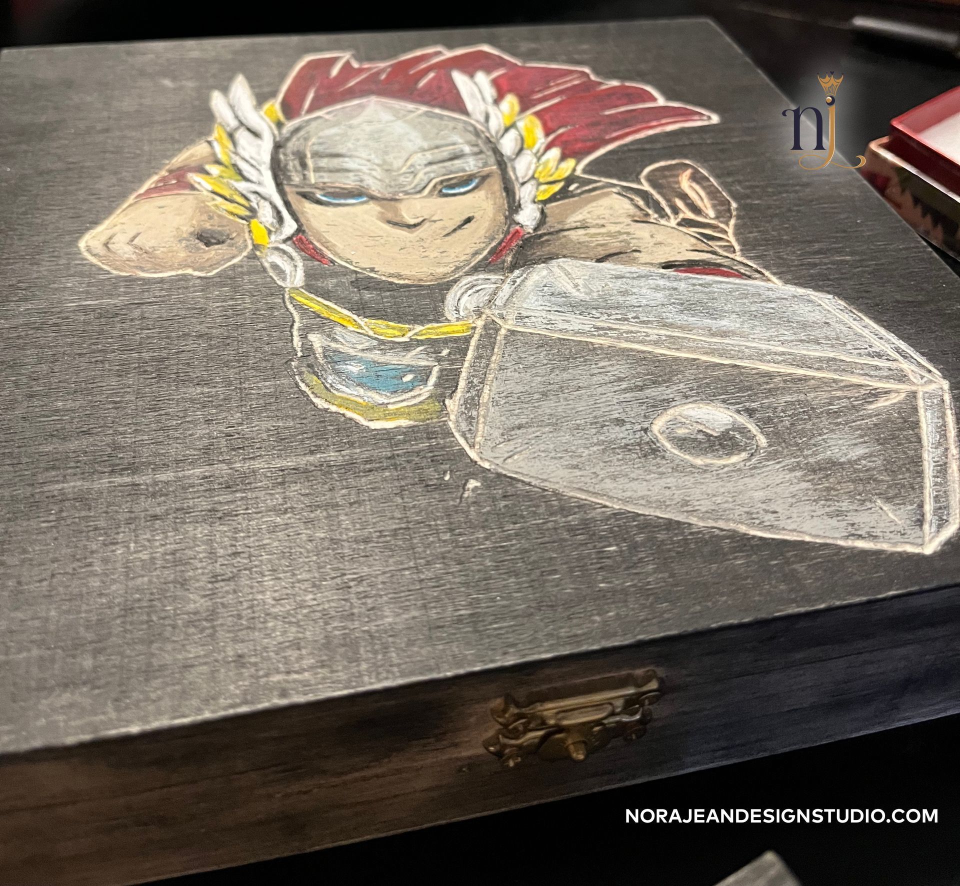 A wooden box with etched Thor character on it