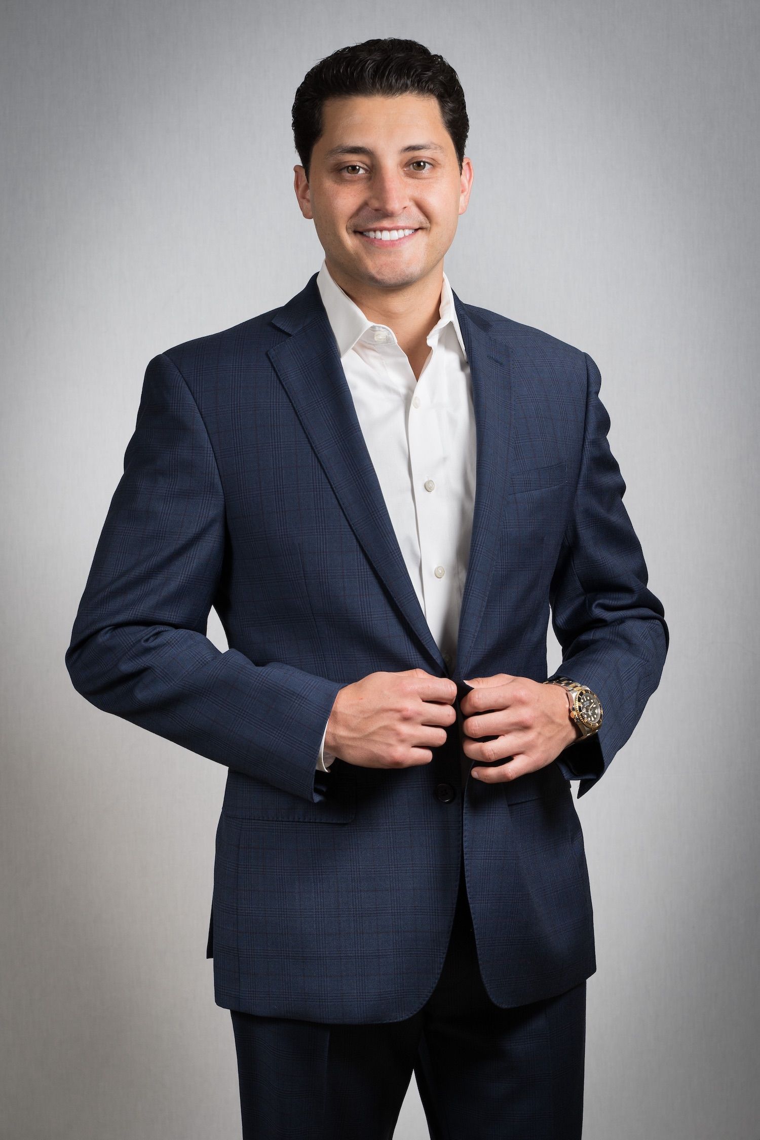 A man and a woman are sitting on a dock overlooking a lake.