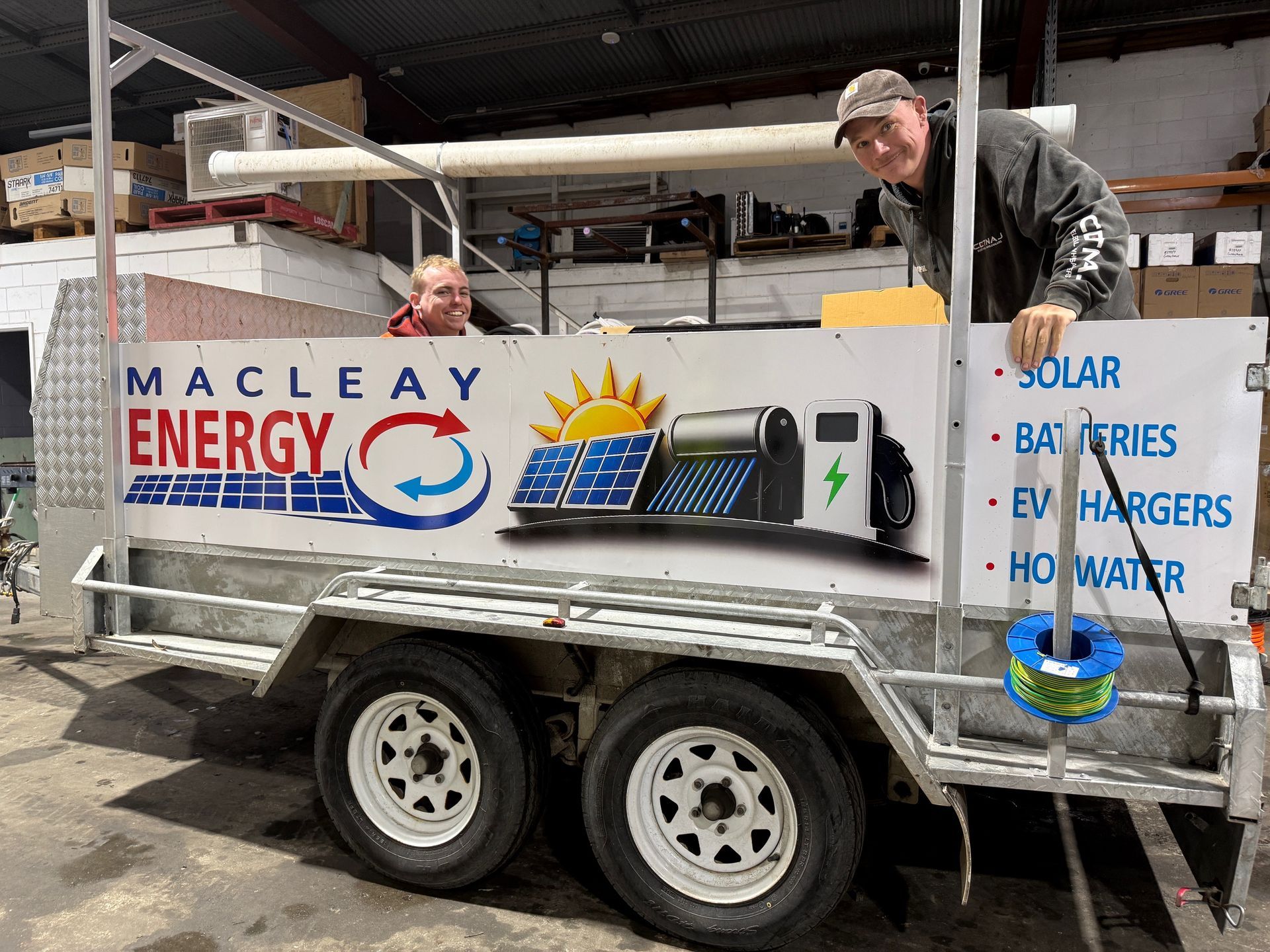A Person Installing Solar Panels on a Sunny Rooftop — Macleay Energy Solutions In Kempsey, NSW
