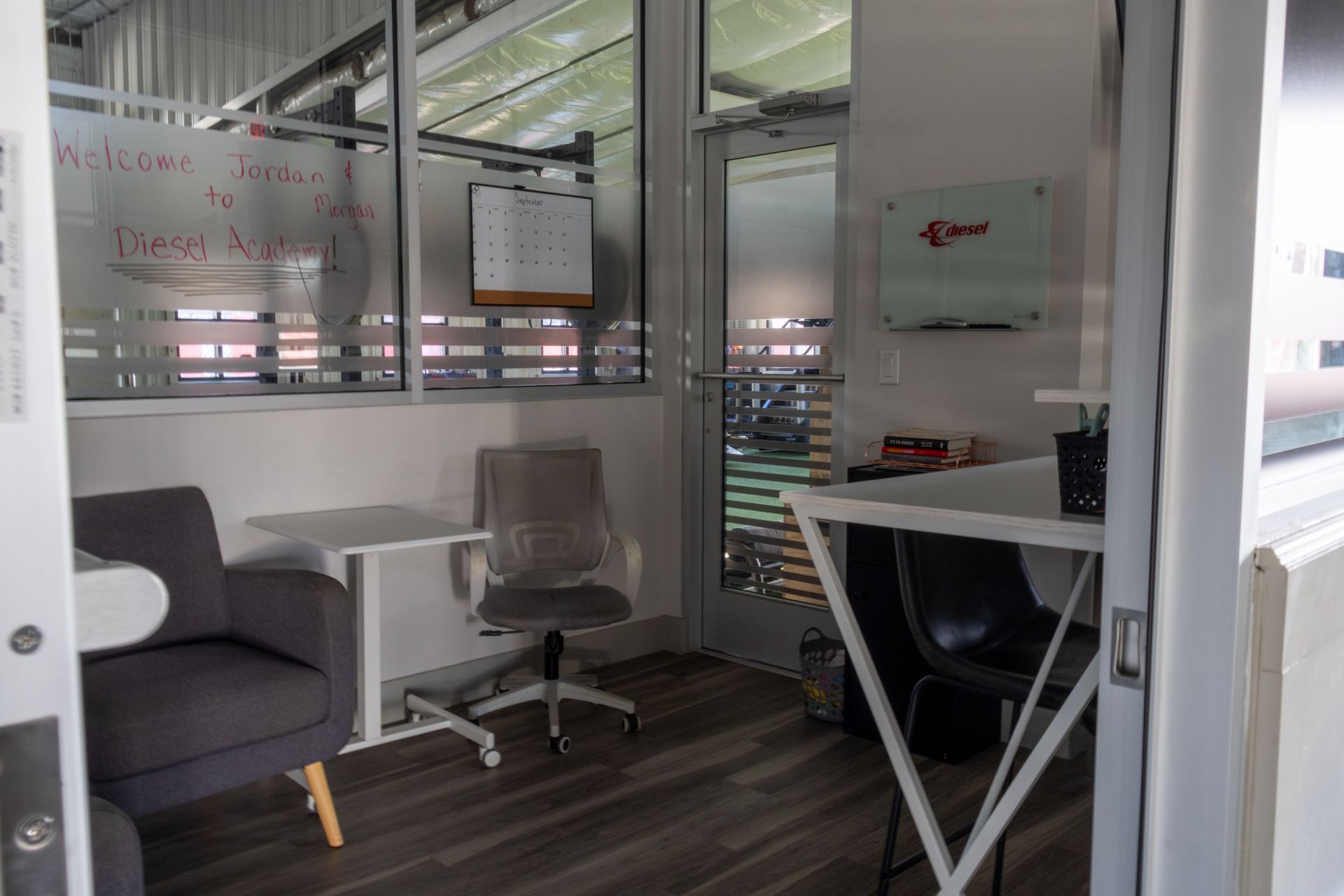 A room with a chair , desk , and whiteboard.