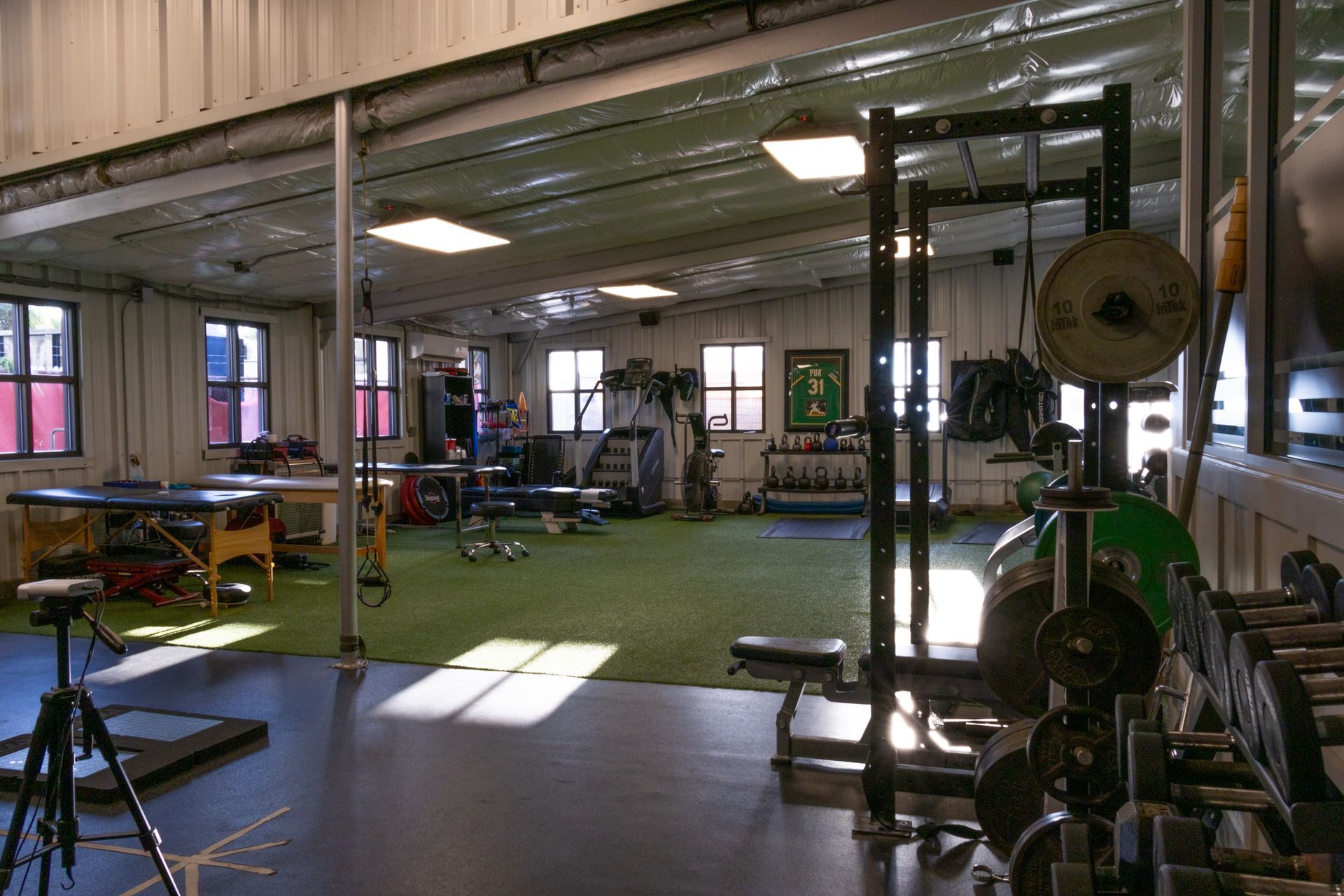 A large gym filled with lots of exercise equipment and a table.