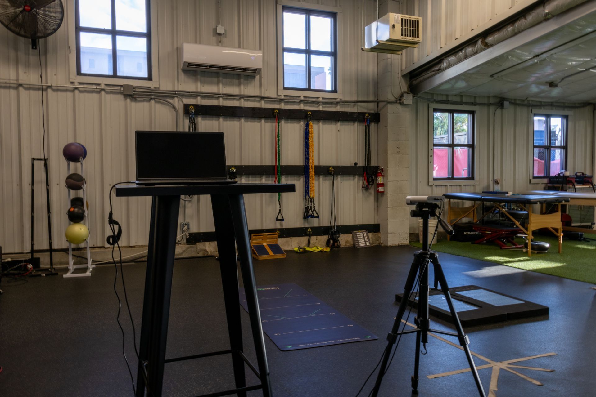 There is a laptop on a table in the middle of a gym.