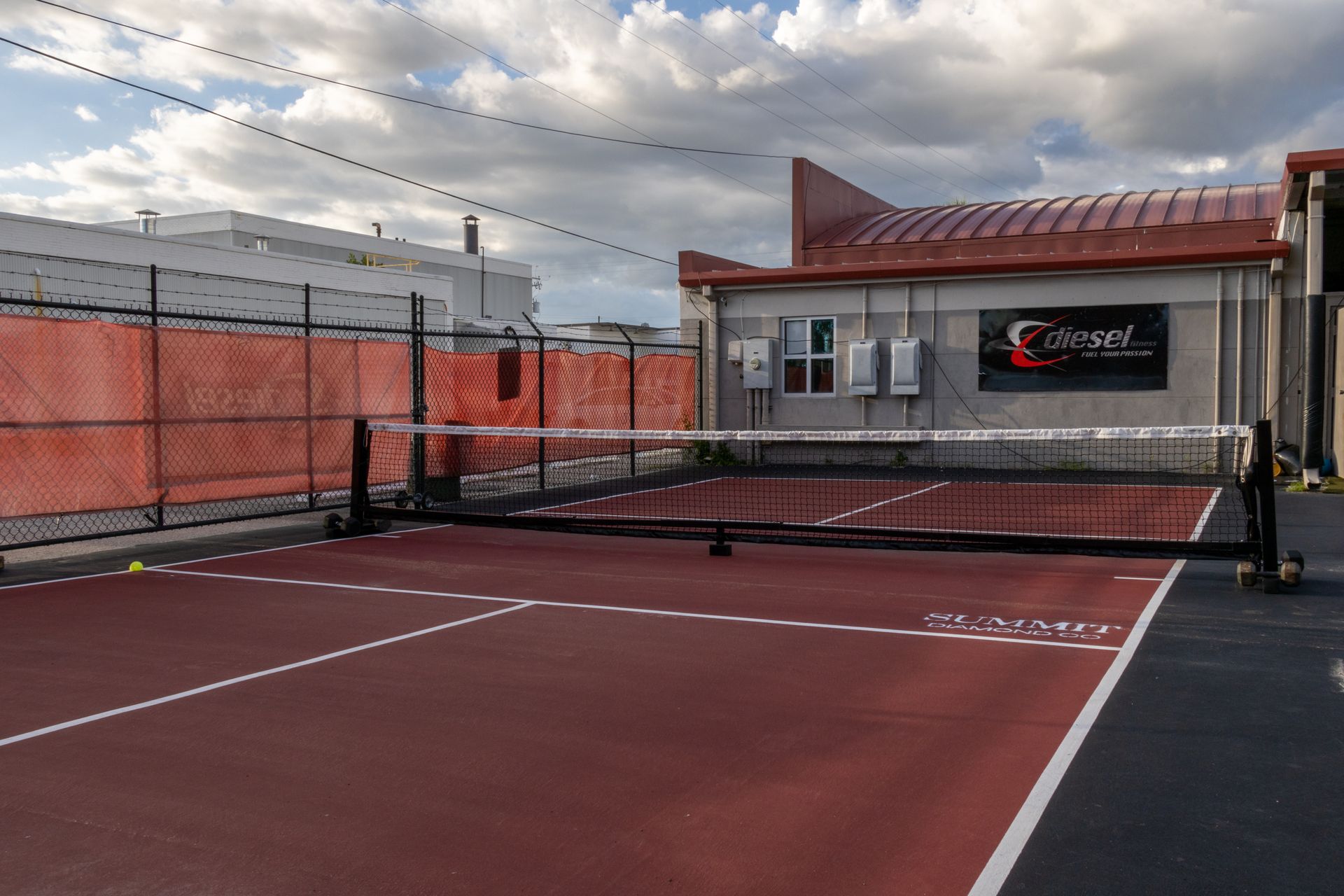 A tennis court in front of a building that says cougars